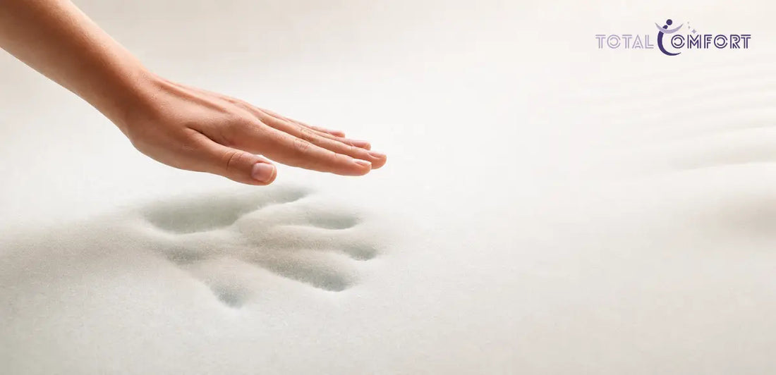 Hand pressing into a memory foam mattress, demonstrating its cushioning and responsiveness.