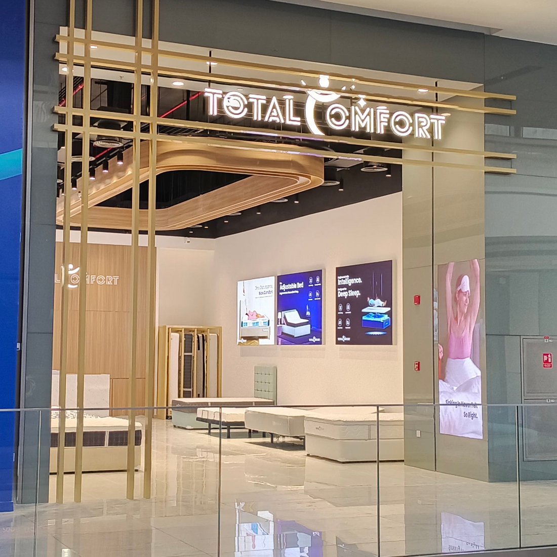 Total Comfort store interior with digital displays and furniture.